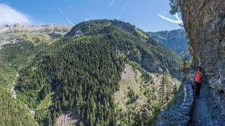 Frau wandert an schmalem Bergweg