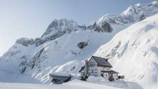 Blick auf das Rifugio Celso Gilberti mit den Gipfeln des Kanin-Massivs.