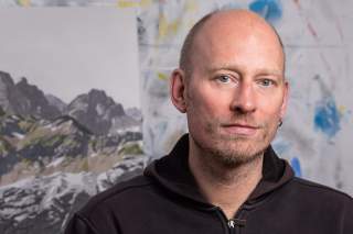 Der Künstler Benjamin Vogel aus Dortmund mit zwei seiner Werke im Hintergrund.