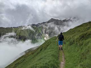 Wanderer auf schmalem Bergweg in den Alpen