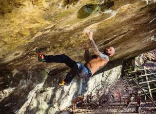 Mann bouldert ab überhängender Felswand