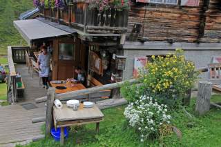 Gäste sitzen auf der Terrasse der Volkzeiner Hütte