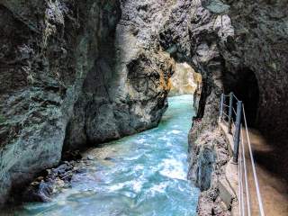 Blick in Klamm mit hellblauem Wasser und angelegtem Wanderweg