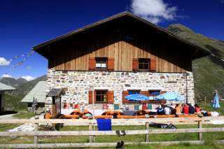 Terrasse vor Berghütte aus Stein und Holz