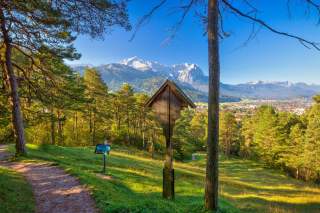 Schmaler Wanderweg mit Blick auf verschneite Gipfel