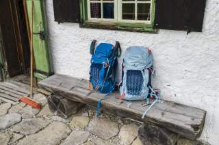 Zwei Rucksäcke auf einer Bank vor einer Hütte