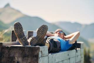 Wanderer liegt auf einer Bank