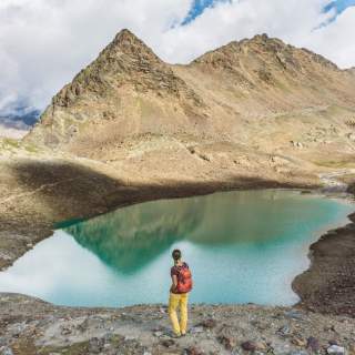Wanderin vor türkisgrünem Bergsee