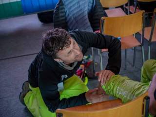 Physiotherapeut kümmert sich um Wade eines Athleten