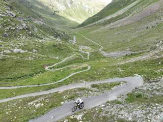 Gravelbiker fährt Schotterserpentinen hinauf