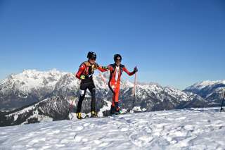 Zwei Skibergsteiger auf Schnee mit Bergpanorama
