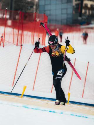 Finn Hösch mit Skiern auf dem Rücken steigt eine steile Tragepassage während eines Skimo-Sprintwettbewerbs hinauf.
