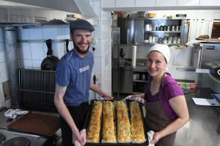 Hüttenwirtsleute in der Küche mit frisch gebackenem Brot