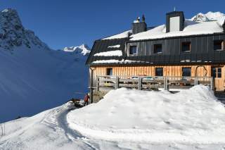 Hütte im Schnee bei Sonnenschein