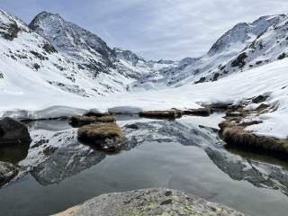 Schneebedeckte Gipfel spiegeln sich in kleinem Teich