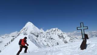 Skitourengeher am Gipfel der Suldenspitze, im Hintergrund Königspitze und Ortler.