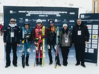 Drei Athletinnen und Skimo Funktionäre stehen in einer Reihe vor einer Werbetafel bei der Europameisterschaft in Shahdag