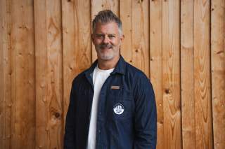 Porträt Engelbert Fuchs vor Holzwand