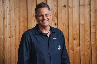 Porträt Hermann Gruber vor Holzwand