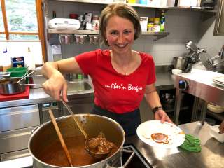 Hüttenwirtin in der Küche beim Gulasch kochen