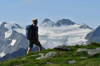 Wanderer auf Höhenweg vor Bergkulisse