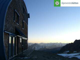 Hütte im Abendlicht mit Ausblick über Gipfel