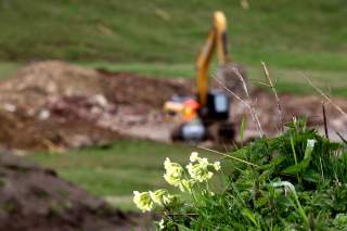 Ein Bagger steht auf einer Bergwiese