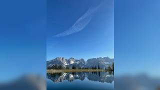 Hochgebirgskette spielt sich in einem See.