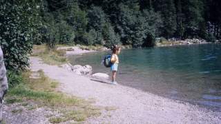 Vintagefoto wo Tamara ganz alleine mit einem Rucksack am See steht und in die Ferne blickt.