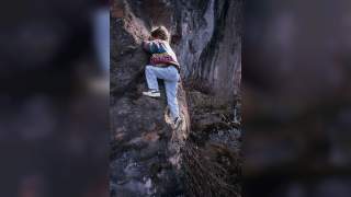 Vintage-Foto von Tamara als kleines Mädchen beim Klettern an einem Felsen.