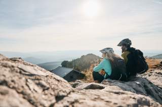 Zwei Menschen genießen Ausblick auf Gipfel