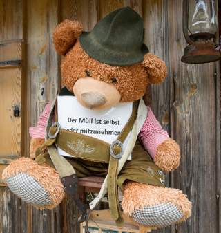 Teddy an Hüttenwand mit Info, Müll wieder mitzunehmen