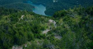 Vogelperspektive auf drei Menschen auf Mountainbikes bei Trailabfahrt