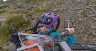 Person trägt Mountainbike auf Schultern