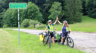 Zwei Frauen stehen mit ihren Fahrrädern am Masererpass bei Reit im Winkl.