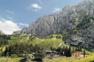 Die Tutzinger Hütte liegt unmittelbar an der Nordseite der Benediktenwand.