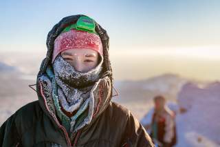 Mensch im Winter mit warmer Kleidung und Stirnlampe