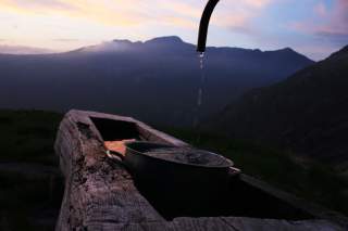 Abendstimmung am Berg, Wasser tröpfelt in einen Topf