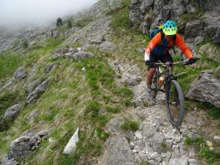 Mountainbiker auf schmalem und felsigem Pfad.