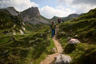 Gruppe von Menschen wandert durch Bergkulisse