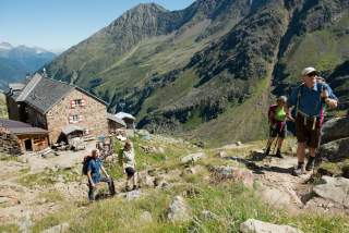 Vier Menschen wandern von Hütte weg