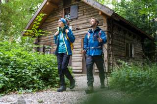 Zwei Personen wandern von Hütte weg