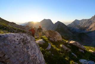 Zwei Menschen wandern in alpiner Landschaft