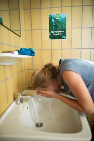 Frau wäscht sich am Waschbecken