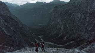 Zwei Menschen steigen in der Morgendämmerung einen Berg hinauf