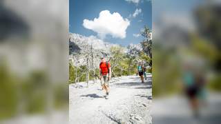 Menschen wandern durch kahle Berglandschaft