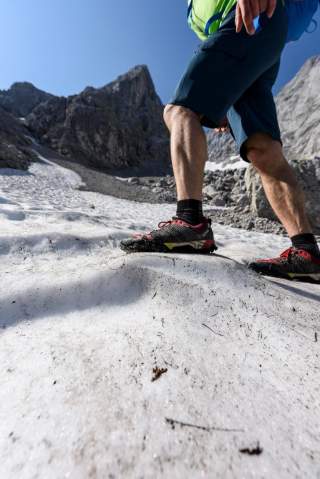Wanderer auf Schneefeld in den Bergen