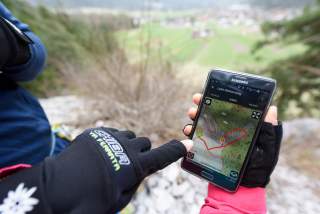 Mensch bedient Handy am Berg