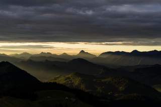 Dunkle Wolken liegen über Berglandschaft