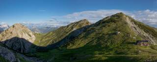 Die Weilheimer Hütte vor Bergpanorama im Sommer